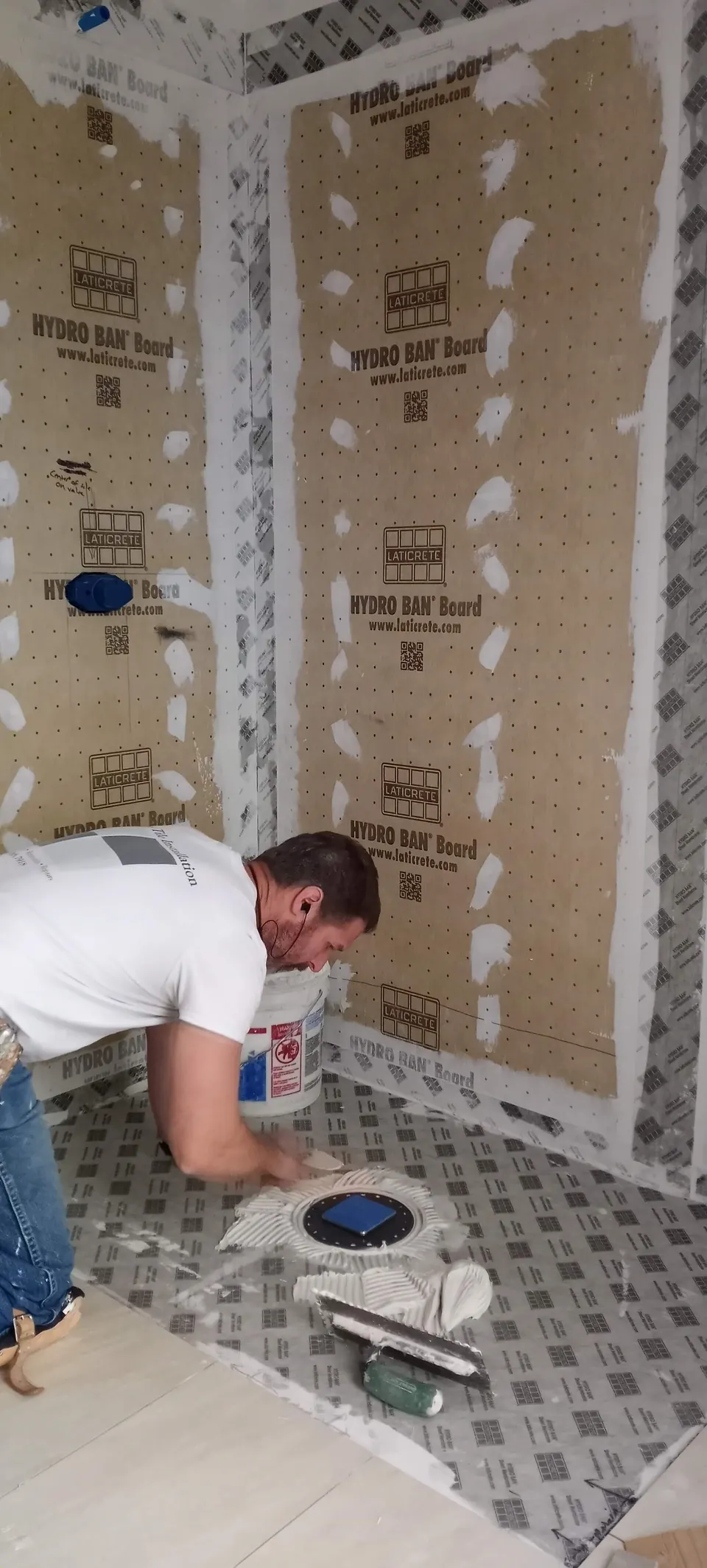 Brian spreading thinset on a waterproofed shower floor inside walls of waterproof foam board